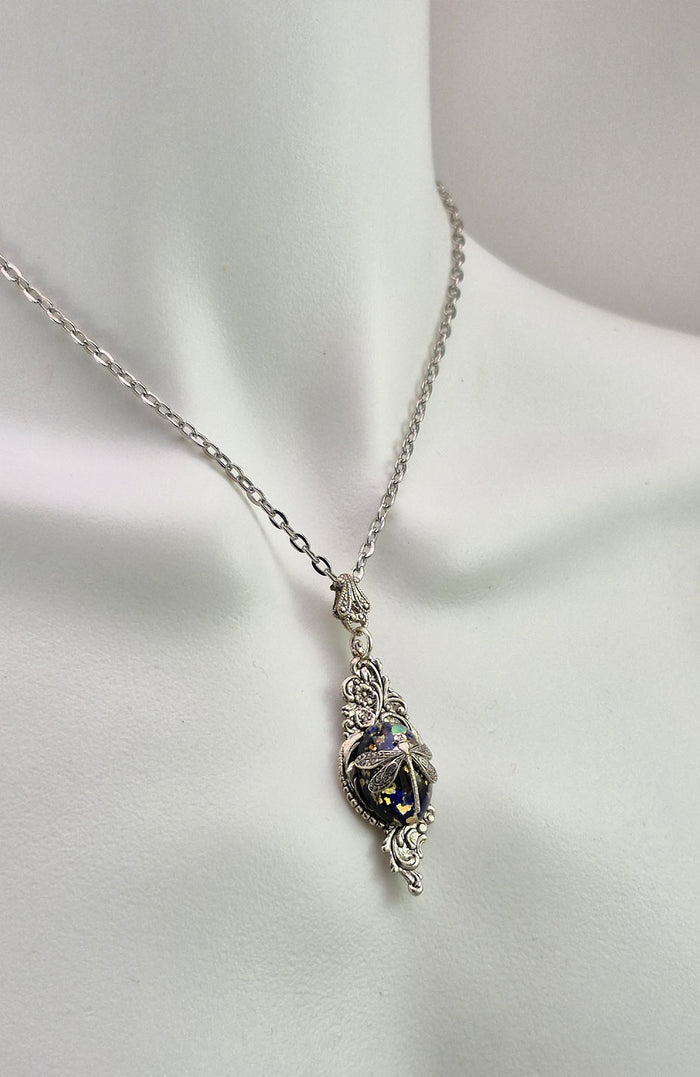 Sterling silver filled Victorian antique or reproduction work from original mold. The pendant features a silver floral design surrounding a central blue, green & gold antique Art Glass cabochon with a dragonfly motif.