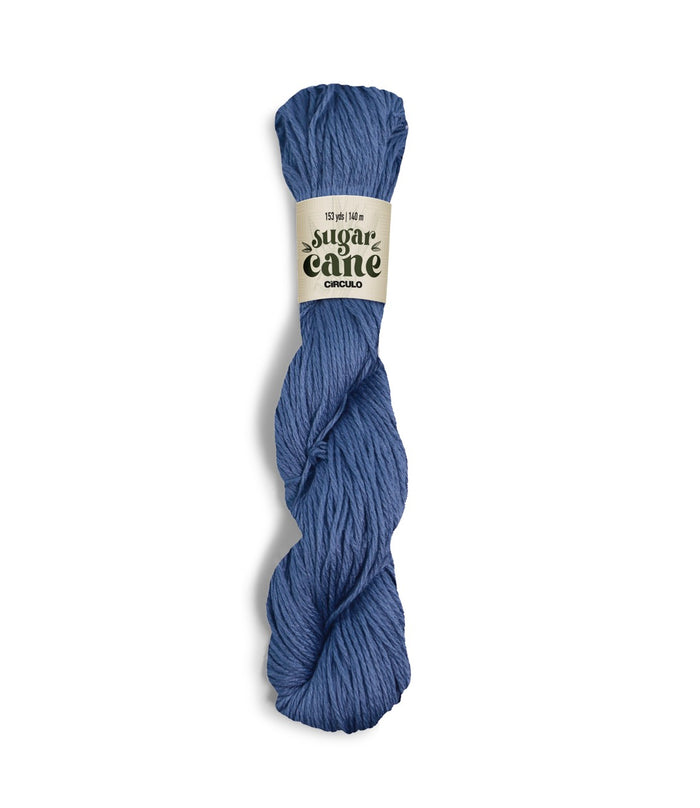 An image of a skein of Circulo DK weight yarn in a blue color with a ‘Sugar Cane’ label against a white background.