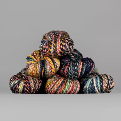 Skeins of Spincycle Plump Bulky weight yarn in black, blue, pink, and yellow color gradient